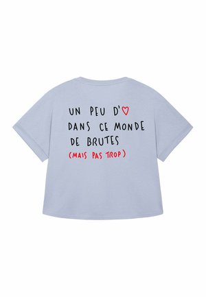 Svijetloplava oversized majica s natpisom na leđima: "Un peu d'amour dans ce monde de brutes (mais pas trop)" i simbol crvenog srca.