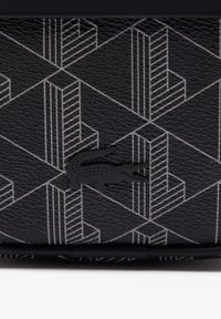 Black textured material with geometric white lines. Features a black crocodile logo. Design includes three-dimensional shapes and patterns.