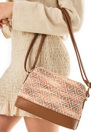 Gewebte Tasche mit einem geometrischen Muster in Orange und Braun, mit einem braunen Lederboden und doppelten Schulterriemen.