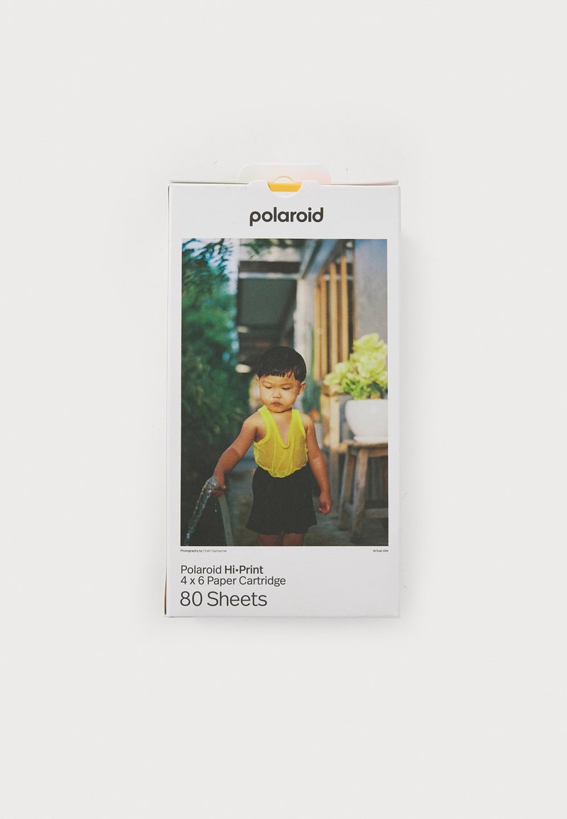 L'emballage de la cartouche de papier Polaroid Hi-Print présente une photo colorée d'un enfant portant un haut jaune vif, mettant en avant 80 feuilles de papier 4x6.