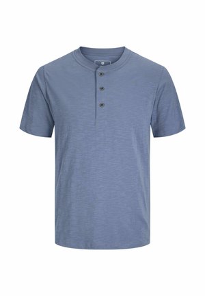 Kratek rokav, henley stil srajce v svetlo modri barvi z teksturiranim vzorcem, ki vsebuje tri črne gumbe na sprednjem delu.