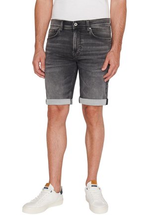 Pantalones cortos de mezclilla gris oscuro con puños enrollados, diseño de cinco bolsillos y costuras en contraste. Combinados con zapatillas blancas y una camiseta blanca sencilla.
