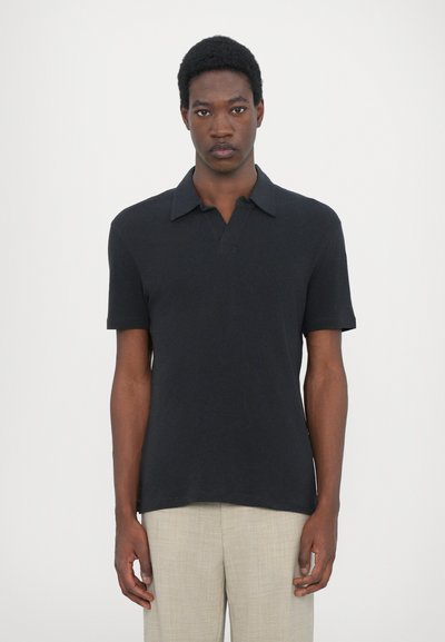 Zwarte poloshirt met een kraag, korte mouwen, gemaakt van een gestructureerde stof. Opvallend door het eenvoudige, klassieke ontwerp.