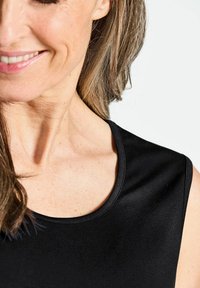 Schwarzes ärmelloses Top mit rundem Ausschnitt, glatter Textur und minimalistischem Design. Nahaufnahme des Stoffs und des Kragenbereichs.