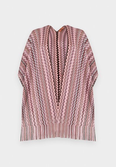 Poncho avec motif zigzag rose, noir et blanc, col en V et franges multicolores le long de l'ourlet sur un fond uni.