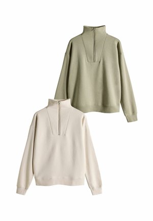 Twee zip-neklongsweaters: één in lichtbeige en één in olijfgroen, met een losse pasvorm, lange mouwen en dubbel stikseldetails.
