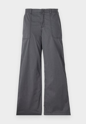 Calças largas cinzentas com uma textura suave, apresentando bolsos frontais, um fecho de botão e detalhes costurados ao longo das costuras.