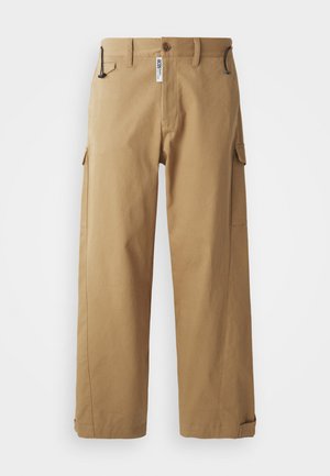 Beige cargobroek van katoen, met brede pijpen, een knoopsluiting aan de voorkant en zijzakken. Soepele textuur met minimale hardwaredetails.
