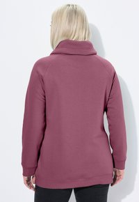 Felpa a maniche lunghe color bordeaux con colletto alto e polsini a coste. Tessuto morbido e texturizzato, con vestibilità rilassata e orlo arrotondato.