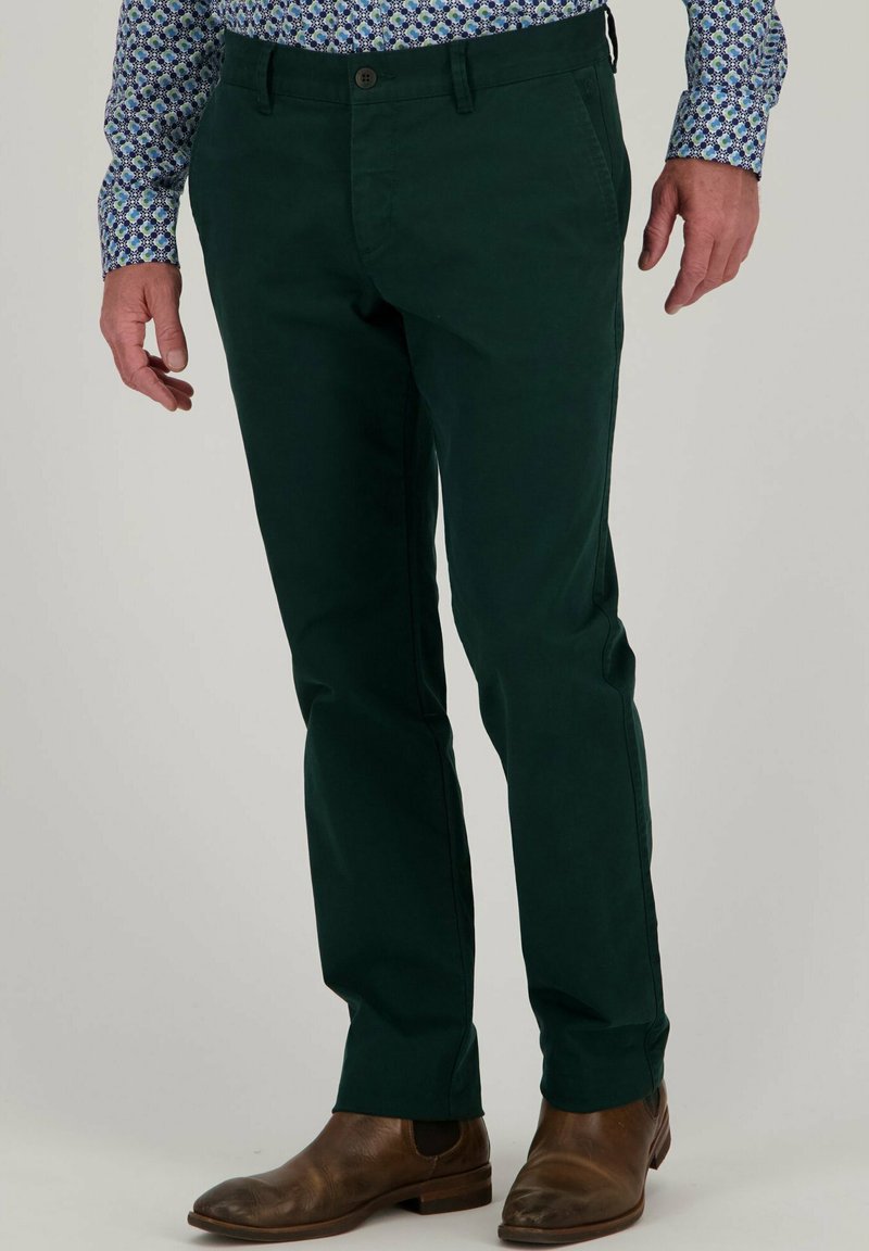 Groene chinos van katoen met een slim fit, voorzien van zijzakken, een knoopsluiting, en gecombineerd met bruine leren boots.