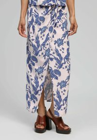 Jupe maxi en tissu léger avec une base rose et des motifs floraux et animaliers compliqués en bleu. Présente une fente à l'avant et une coupe ample.