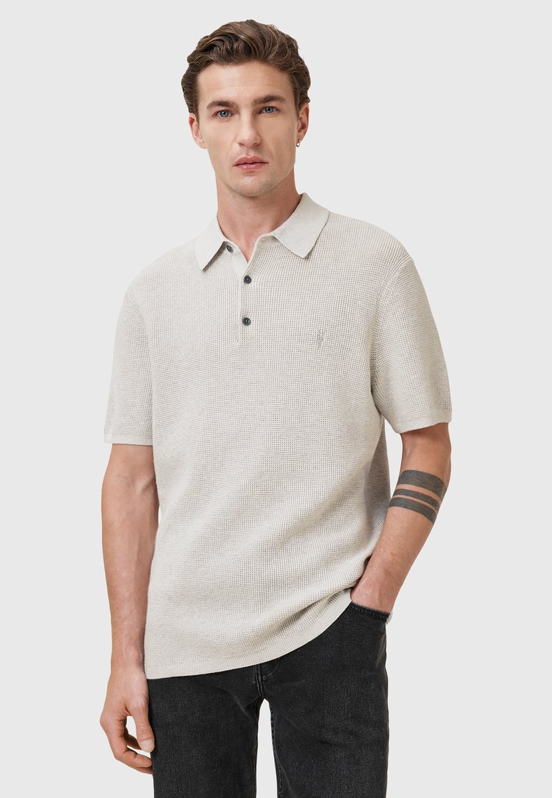 Lichtgrijze polo met korte mouwen van structuurnylon, met een kraag, een sluiting met drie knopen en een subtiele logo op de borst.