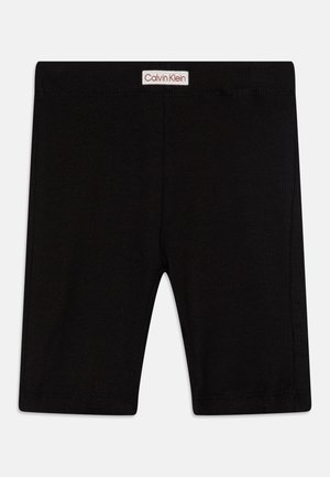 Sorte ribbede bomullsshorts med elastisk midjebånd, med et hvitt og rødt "Calvin Klein"-logo-bånd foran.