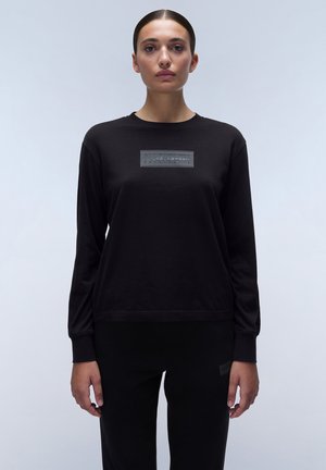 Zwarte sweatshirt met lange mouwen en een ronde halslijn, voorzien van een rechthoekige getextureerde patch op de borst en ribgebreide manchetten.