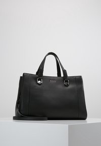 Czarna skórzana torebka z dwoma górnymi uchwytami, srebrnymi akcentami, fakturowanym wykończeniem i odpinanym paskiem na ramię. Logo widoczne na przodzie.