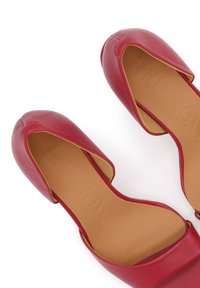Paire de ballerines rouges en cuir pour femmes, avec bouts arrondis et semelles intérieures beiges, vues de dessus sur un fond blanc.