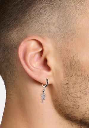 Silberner, schlangenförmiger Ohrring mit schwarzen Akzenten, der ein strukturiertes Design und einen Creolenverschluss aufweist. Wird am linken Ohr getragen.