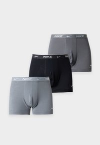 Trois paires de boxers pour hommes Nike en noir et deux nuances de gris, chacun avec un logo sur la ceinture et près de la jambe.
