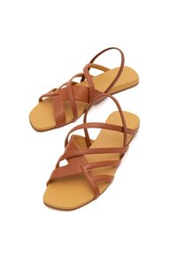 Braune Leder-Sandalen mit sich kreuzenden Riemen, offenes Zehendesign, rechteckige flache Sohle und einer glatten hellbraunen Innensohle.