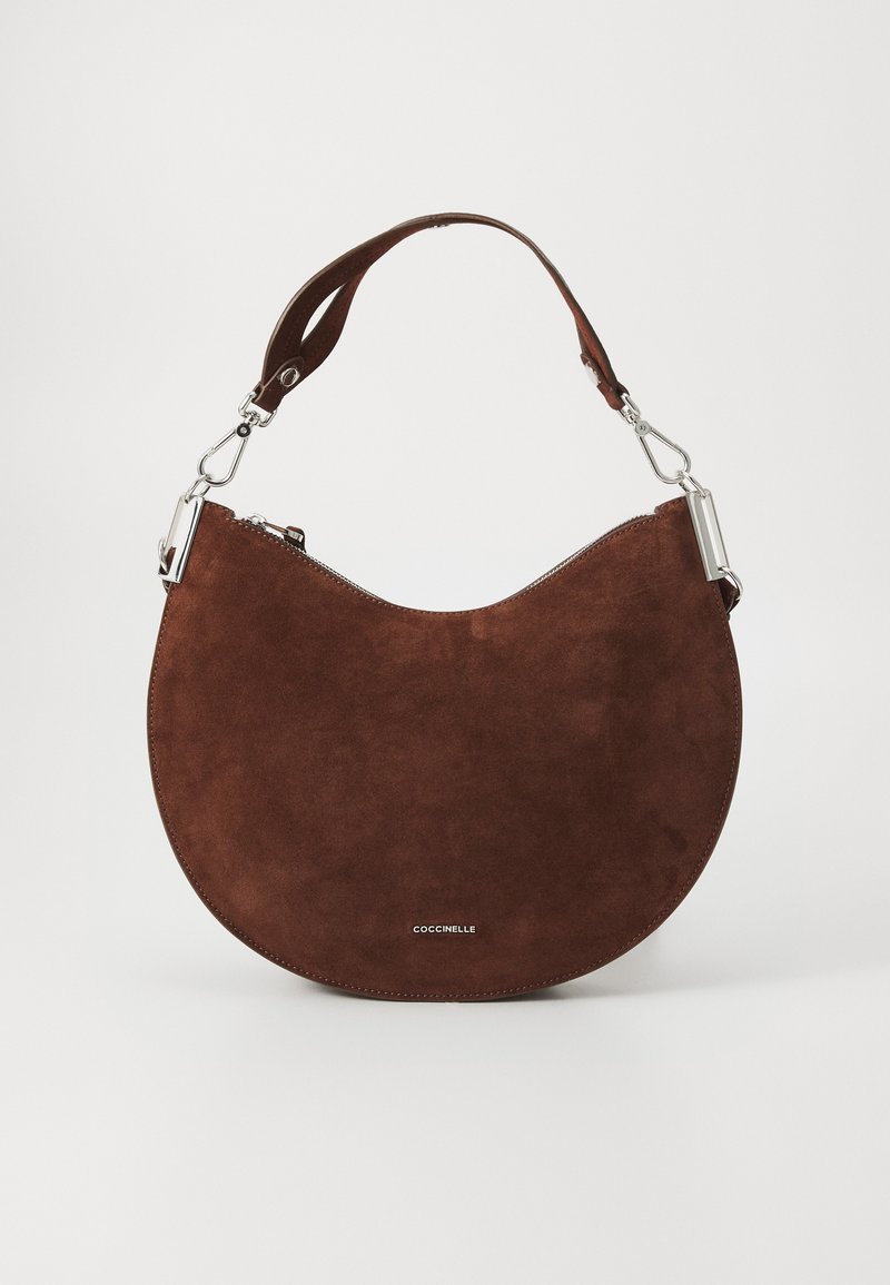 Borsa in suede marrone con silhouette curva, finiture in argento e tracolla corta, dotata di chiusura a zip e branding minimalista sul fondo.