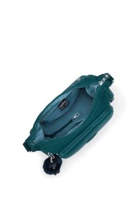 Borsa a tracolla zippata color turchese aperta che mostra un interno foderato in tessuto, una piccola tasca con zip, un gancio per le chiavi attaccato e un portachiavi a pom-pom peloso.
