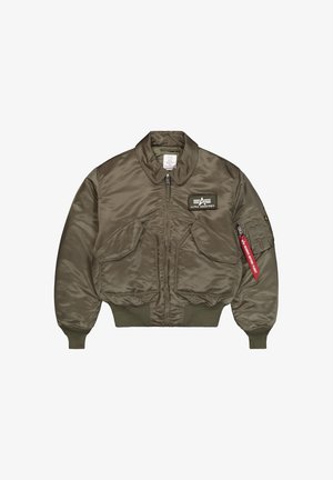 Olivgrüne Bomberjacke mit Frontreißverschluss, zwei schrägen Klappentaschen, gerippten Bündchen, Alpha Industries Aufnäher auf der Brust und rotem "Remove Before Flight" Anhänger am Ärmel.