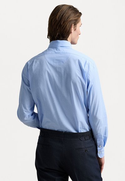 Chemise à manches longues bleu clair avec un petit motif à pois, montrée de dos. Elle présente un col standard et une coupe ajustée.
