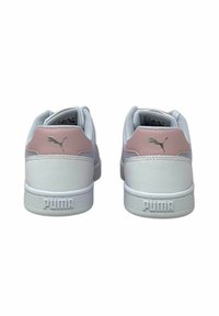 Sneakers bianchi con accenti rosa, parte superiore in pelle liscia, collare imbottito e suola in gomma testurizzata. Presentano il logo Puma cucito e il marchio in rilievo.