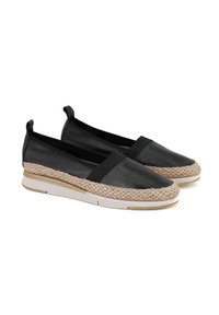 Zwarte instap schoenen met een soepele leren bovenkant, elastische band en een geweven jute middenzool met een witte rubberen zool voor grip.