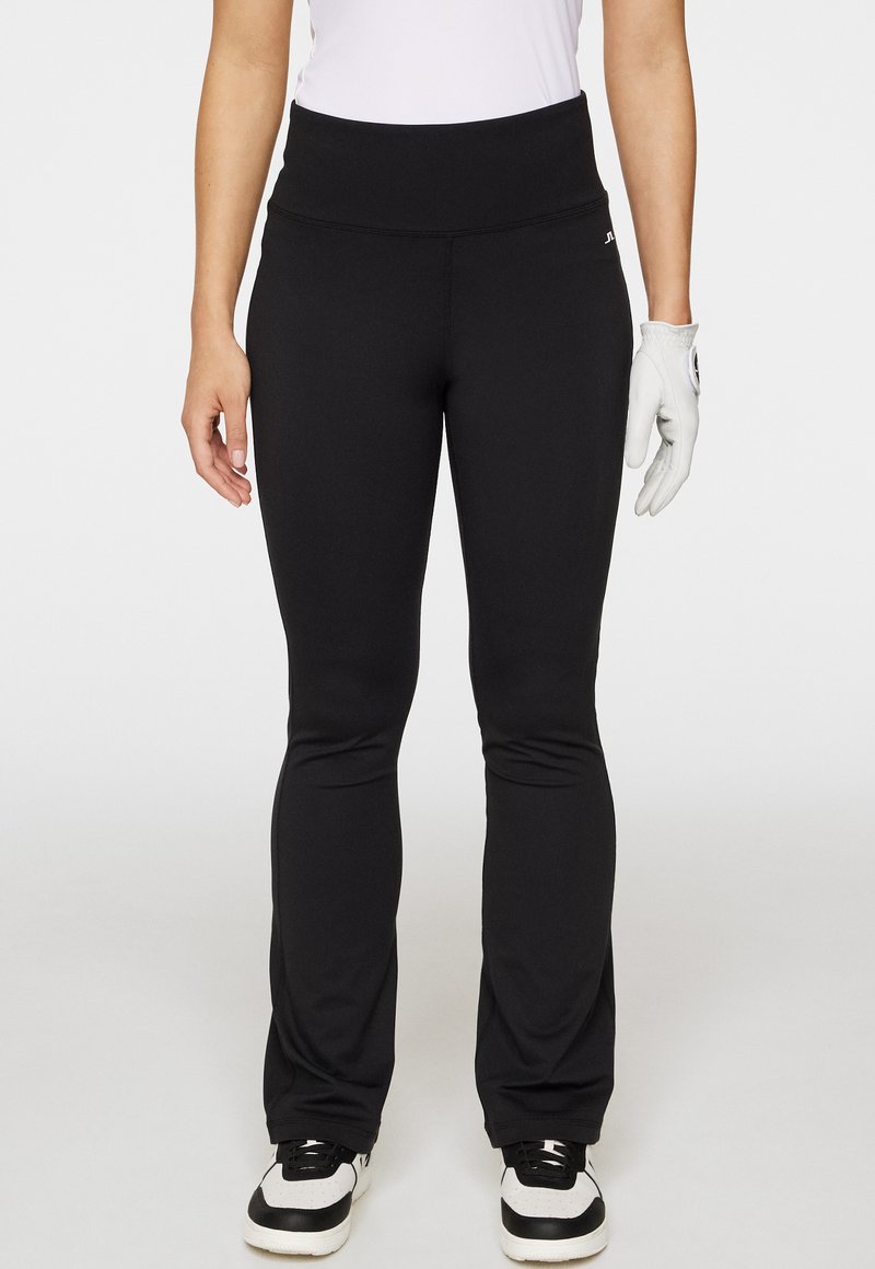 Svarta sportbyxor med hög midja, tillverkade av elastiskt material, med en slim fit genom höfterna och utsvängda ben.