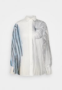 Långärmad skjorta med knappar på vit bakgrund. Vänster sida har blå ränder; högra sidan har abstrakta svarta linjer och mönster.