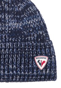 Cappello di lana lavorato a maglia blu navy e bianco con bordo piegato, caratterizzato da una patch triangolare del logo Rossignol in rosso, bianco e nero.