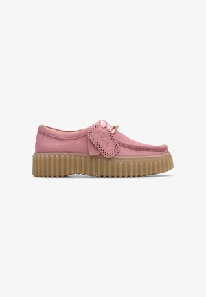Mocassino in suede rosa con plateau, decorato con un'etichetta in pelle scallop e suola traslucida beige spessa e rigata.