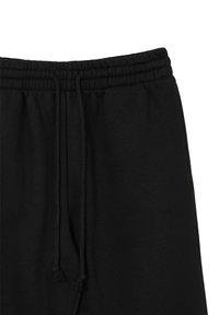 Pantalons de jogging noirs avec une taille élastique, dotés d'un cordon de serrage avec deux glands et d'un tissu doux et texturé.