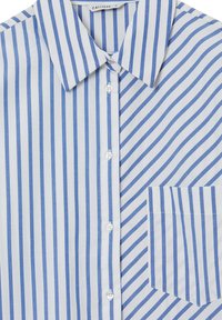 Chemise rayée bleu et blanche avec un col classique, fermeture à boutons et une poche. Fabriquée en tissu lisse avec une texture douce.