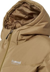 Beige polstret jakke med hætte, frontlynlås og "hummel SPORTSWEAR"-logo på brystet.