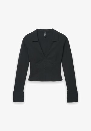 Blusa nera a maniche lunghe cropped con polsini larghi, scollo a V profondo, vita strutturata e piccole chiusure a gancio frontali.