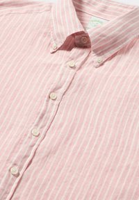 Camicia rosa chiaro con bottoni, caratterizzata da strisce verticali bianche, colletto e chiusura tradizionale con bottoni, realizzata in tessuto texturizzato.