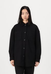 Zwarte wollen mix oversized jas met een kraag, frontsluiting met knopen, twee borstzakken en zijnaad. Soepele textuur en minimalistisch ontwerp.