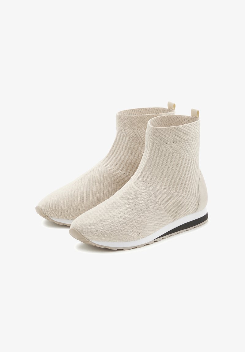 Strick-Ankle-Boots in hellem Beige mit strukturiertem Design, ausgestattet mit einer hellgrauen Gummisohle und kleinen Zuglaschen an der Rückseite für ein einfaches An- und Ausziehen.