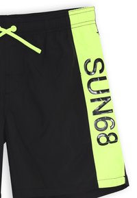 Pantaloni da nuoto neri con un pannello laterale verde brillante che presenta "SUN68" in grassetto lettere nere. Realizzati in materiale leggero, adatti per attività acquatiche.