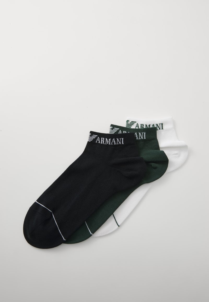 Tres pares de calcetines tobilleros: uno negro con detalles en blanco, uno verde oscuro y uno blanco, todos con un logo de Armani en los puños.