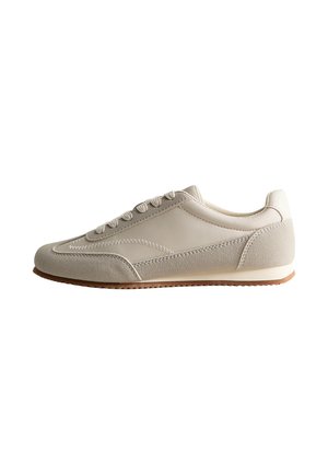 Sneaker casual beige chiaro con texture in camoscio e pelle, allacciatura frontale e suola in gomma, vista laterale su sfondo bianco.
