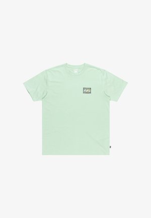 Mentolovo zelené tričko vyrobené z bavlny, s krátkymi rukávmi a štvormou designom vrecka na hrudi, ktoré obsahuje grafiku vlny a akcenty okrajov.