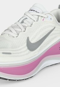 Λευκό και γκρι παπούτσι για τρέξιμο Nike με ροζ λεπτομέρεια στη σόλα και ορατή απορρόφηση κραδασμών «Air Max» στο πλάι.