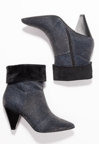 Bottines étincelantes noires et grises avec un bout pointu, un bord en velours et un talon conique texturé. Comprend une fermeture éclair sur le côté pour un enfilage facile.