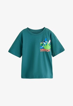 Morska zieleń dziecięcego T-shirtu z postacią Stich pijącą z kokosa, otoczoną tropikalnymi liśćmi i napisem "STITCH" na przodzie.