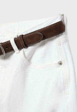 Close-up of white denim pants with a brown suede belt threaded through the waistband and metal button detail.