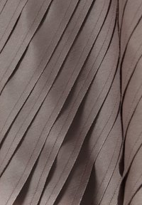 Pleated fabric dalam warna mauve lembut, dengan tekstur mengkilap yang memiliki lipatan vertikal yang teratur dan detail jahitan yang halus.