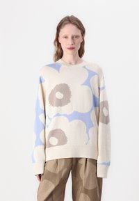 Trikotāžas džemperis krēmkrāsā ar lieliem ziedu rakstiem gaiši zilos un brūnos toņos. Brīva piegriezuma, apaļš kakla izgriezums un ribotās piedurknes un apakšmalas.